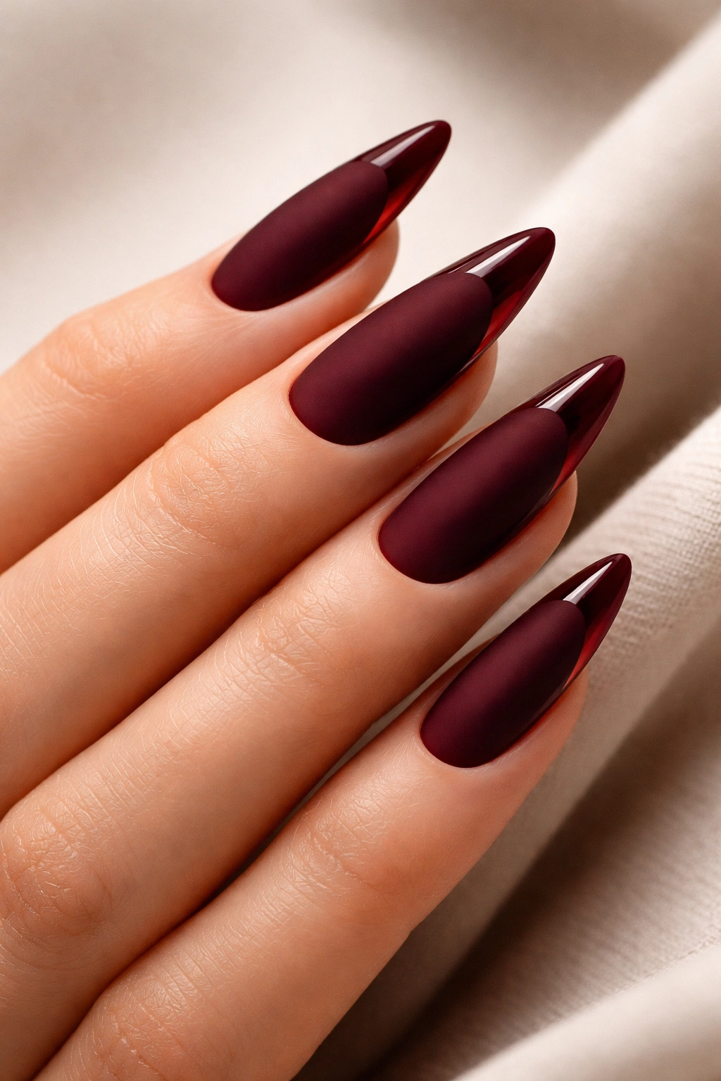 Almond nails with matte deep red base and glossy tip accents