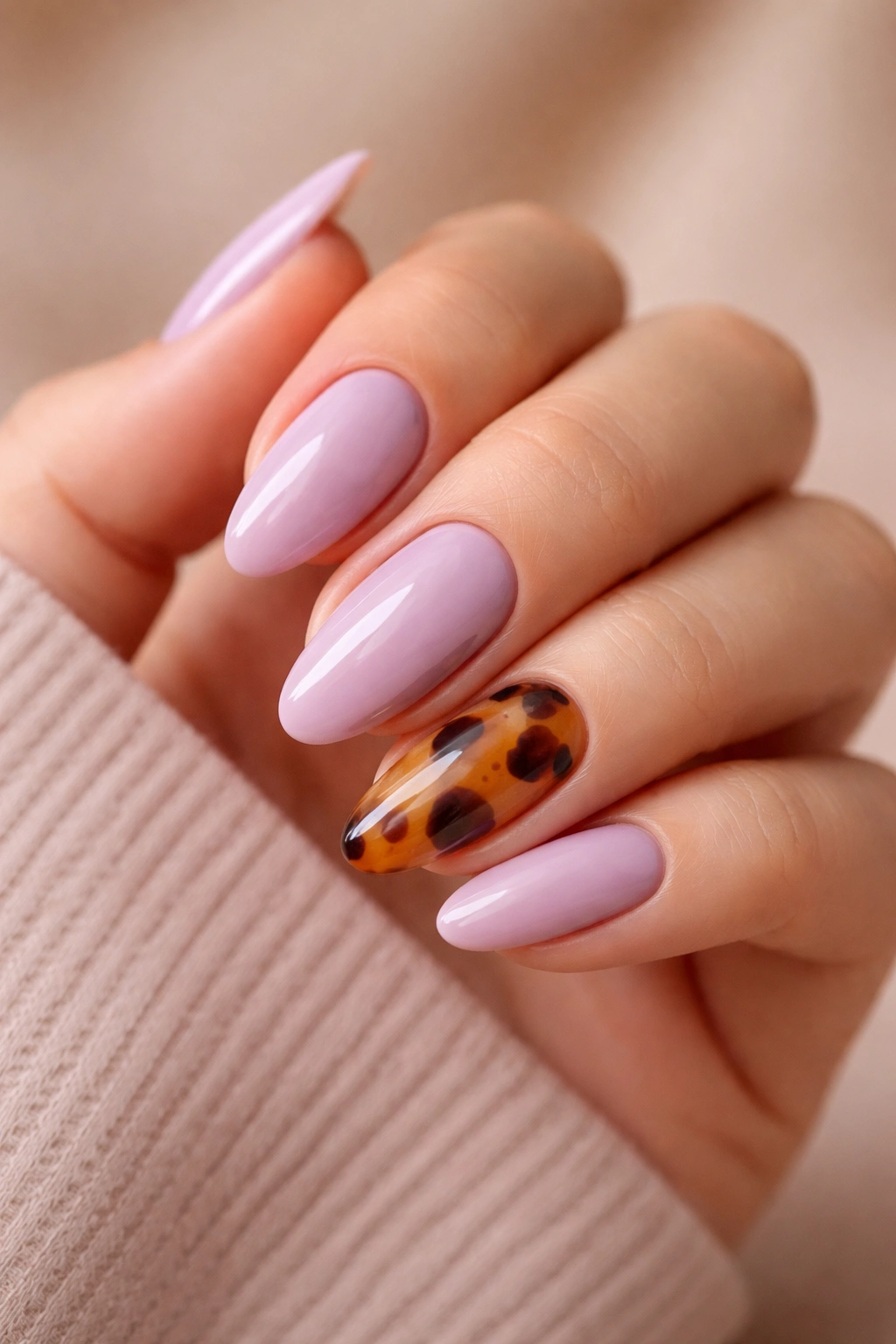 Close-up of mauve-lavender nails with tortoiseshell accent on one almond nail