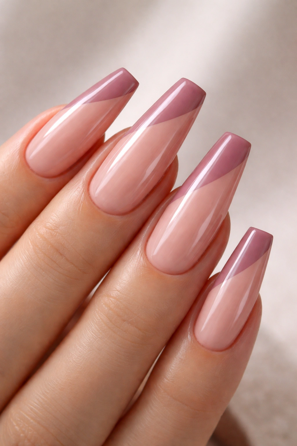 Close-up of coffin nails with a deep side-swept mauve pink French tip