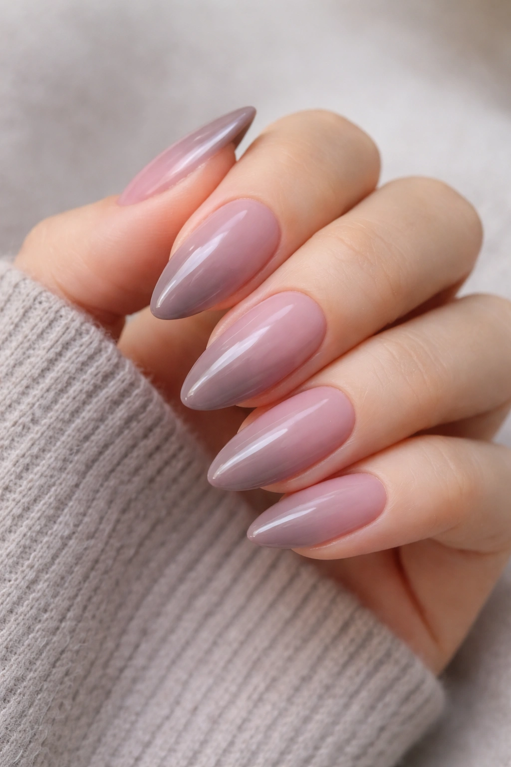 Close-up of mauve to taupe ombre almond nails with glossy finish