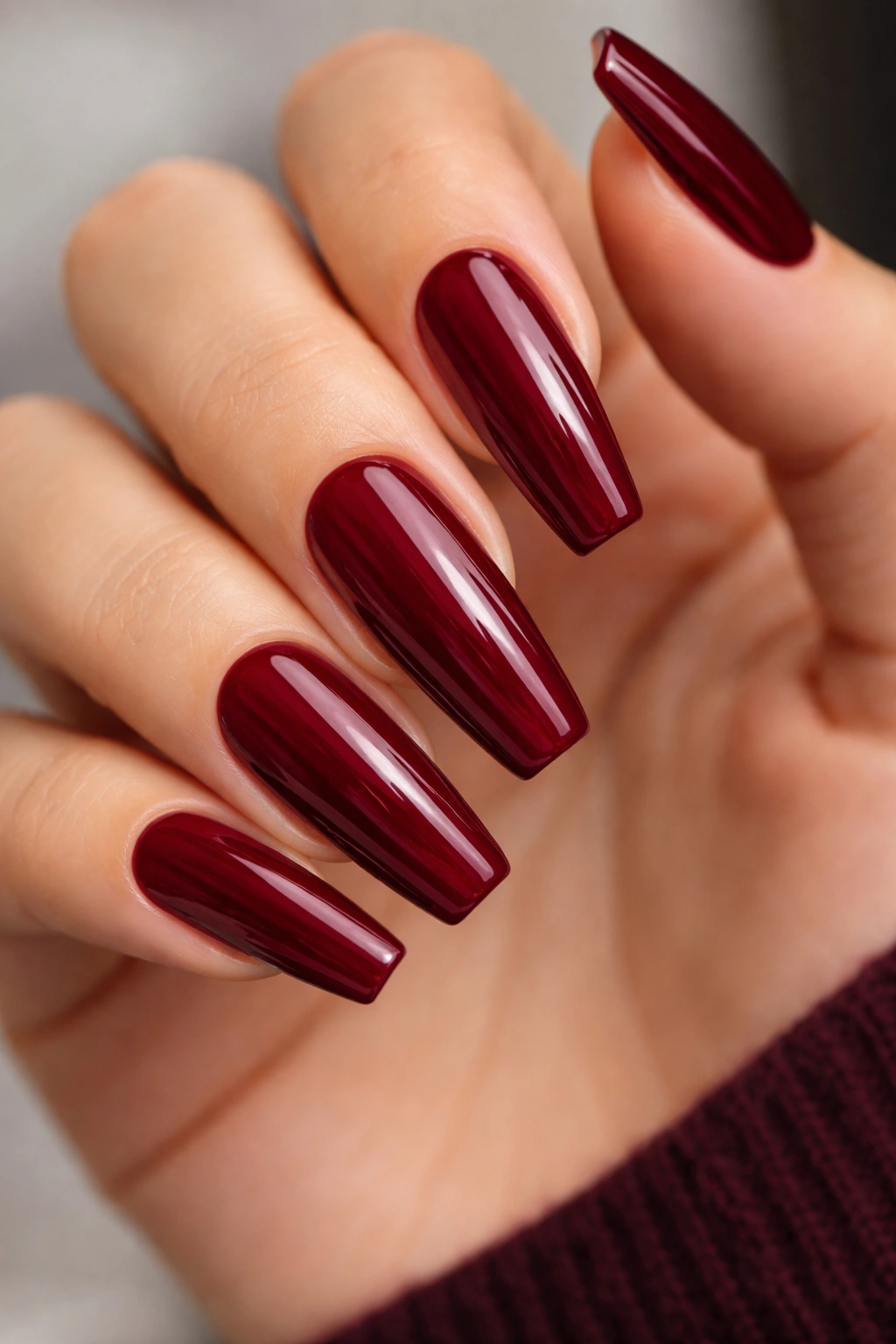 Close-up deep merlot red coffin nails with berry undertones