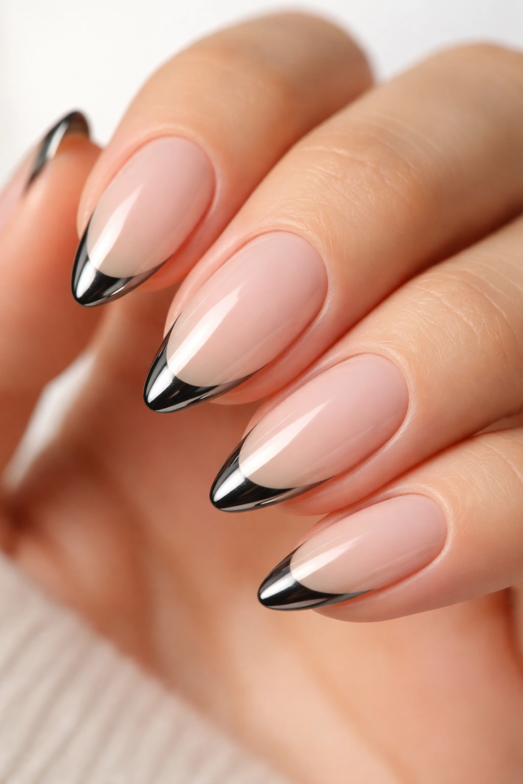 Close-up of micro French black chrome tip on almond nail