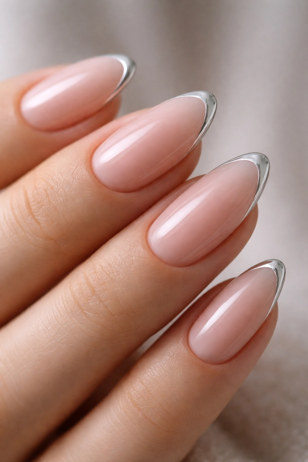 Close-up almond nails with a thin chrome line along the curved almond edge