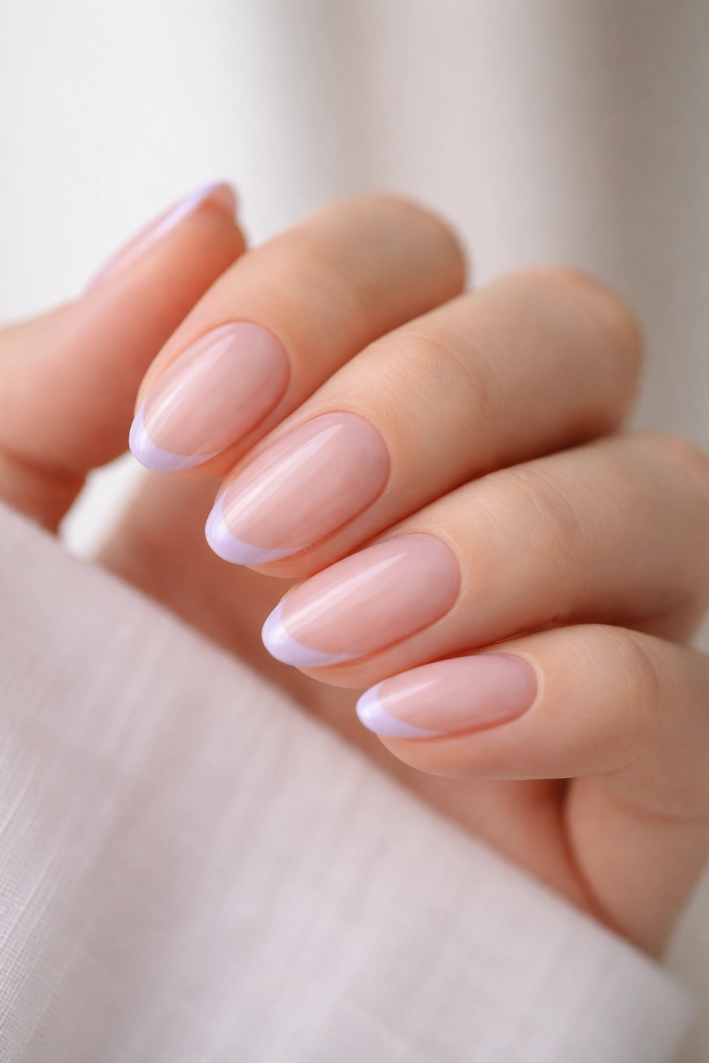 Close-up of almond nails with micro French lavender tips on clear base