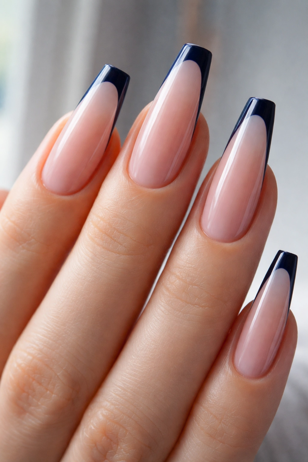 Long coffin nails with ultra-thin navy tips on a sheer base