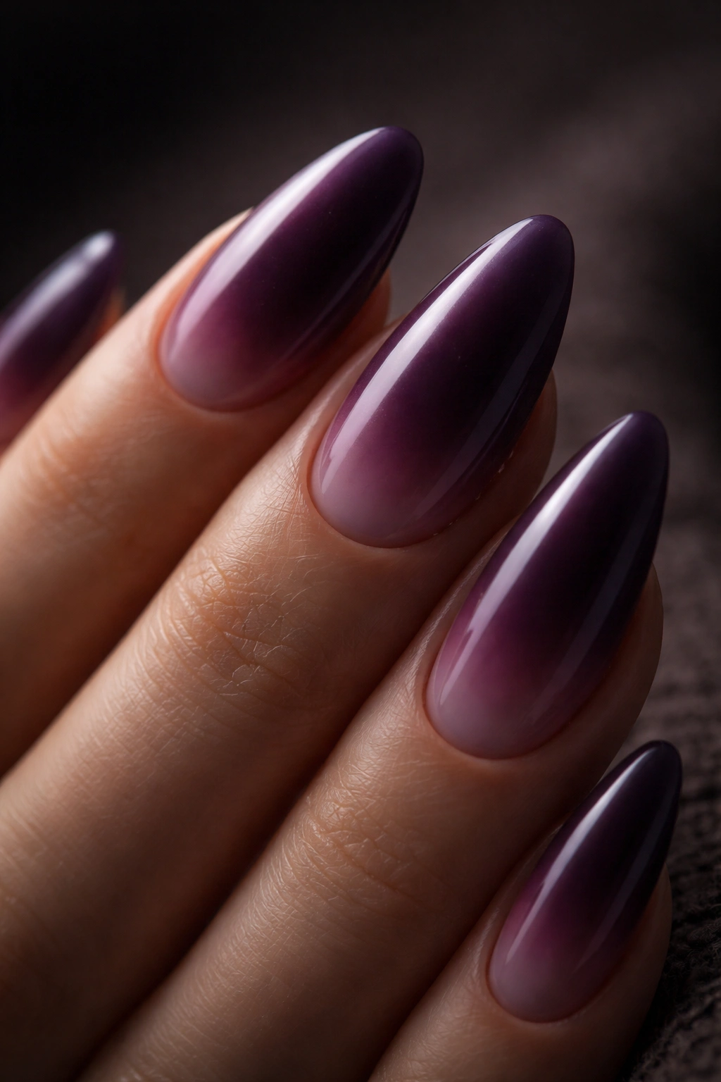Close-up almond nail with midnight plum aura gradient from deep plum center to mauve edge.