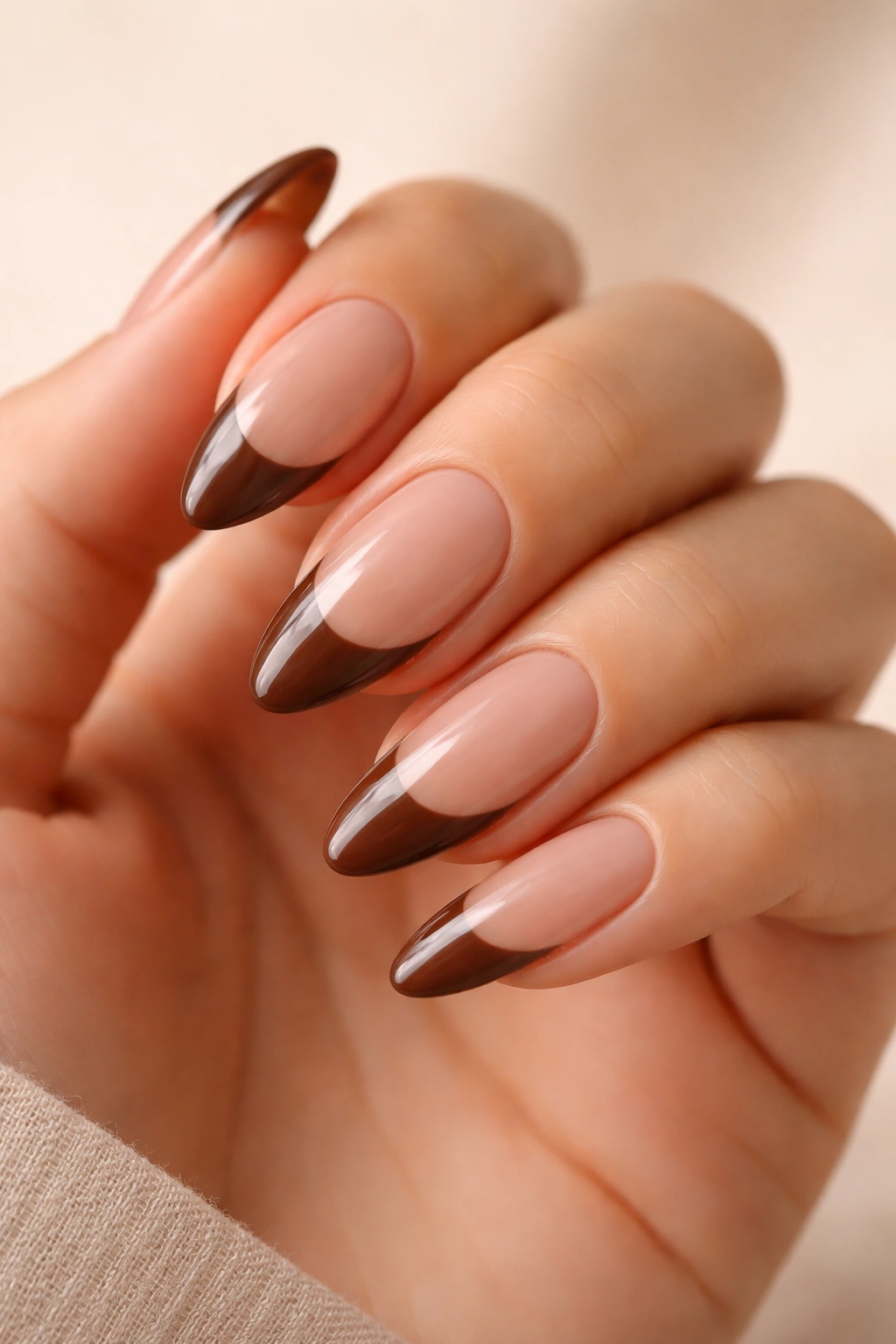 Almond nails with sheer nude base and milk chocolate French tips