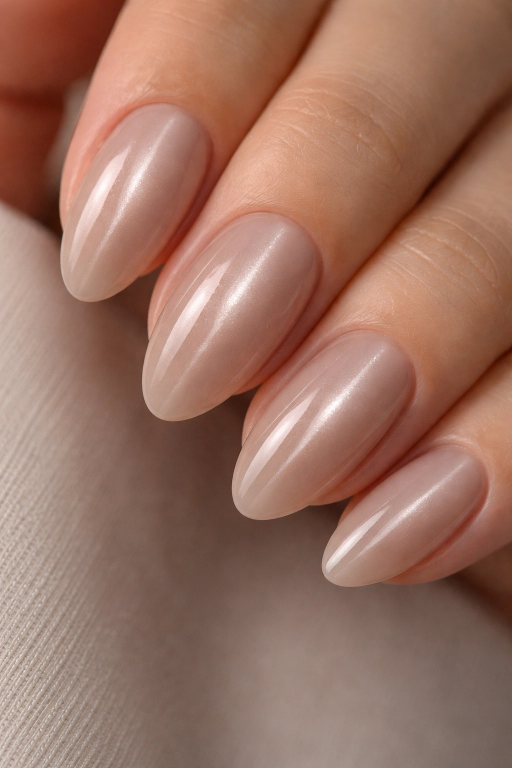 Almond nail with sheer taupe base and centered cat eye shimmer