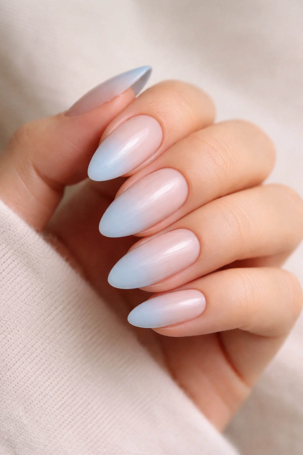 Milky blue ombré on almond nails fading softly