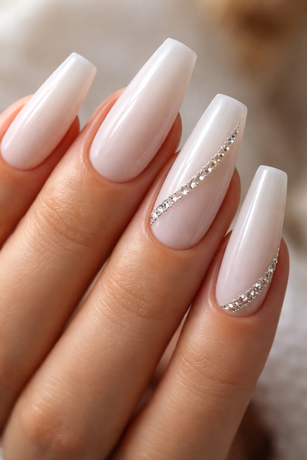 Milky white coffin nails with a side-swept crystal line along the edge