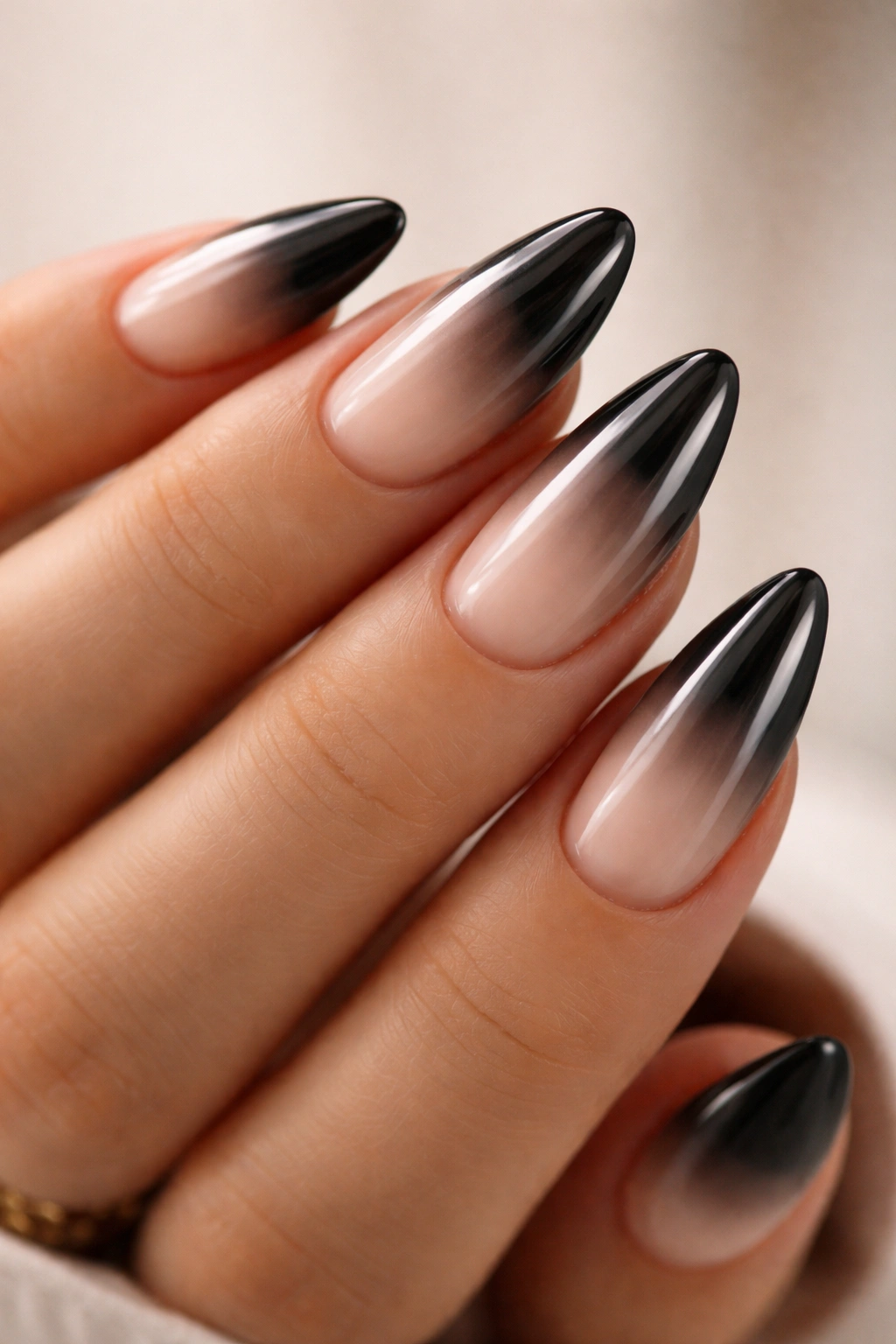 Almond nails with milky nude fade blending into black chrome