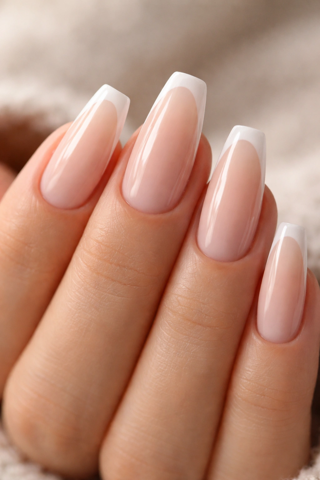 Close-up of milky nude coffin nails with a whisper-thin white line