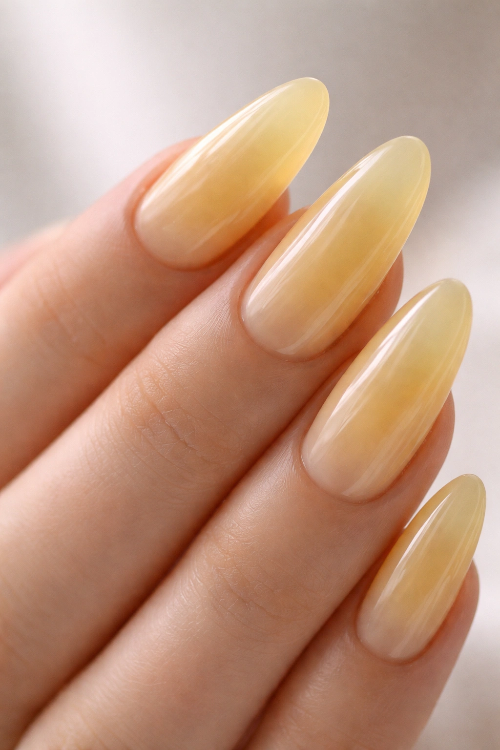 Milky yellow jelly almond nails with translucent glossy finish