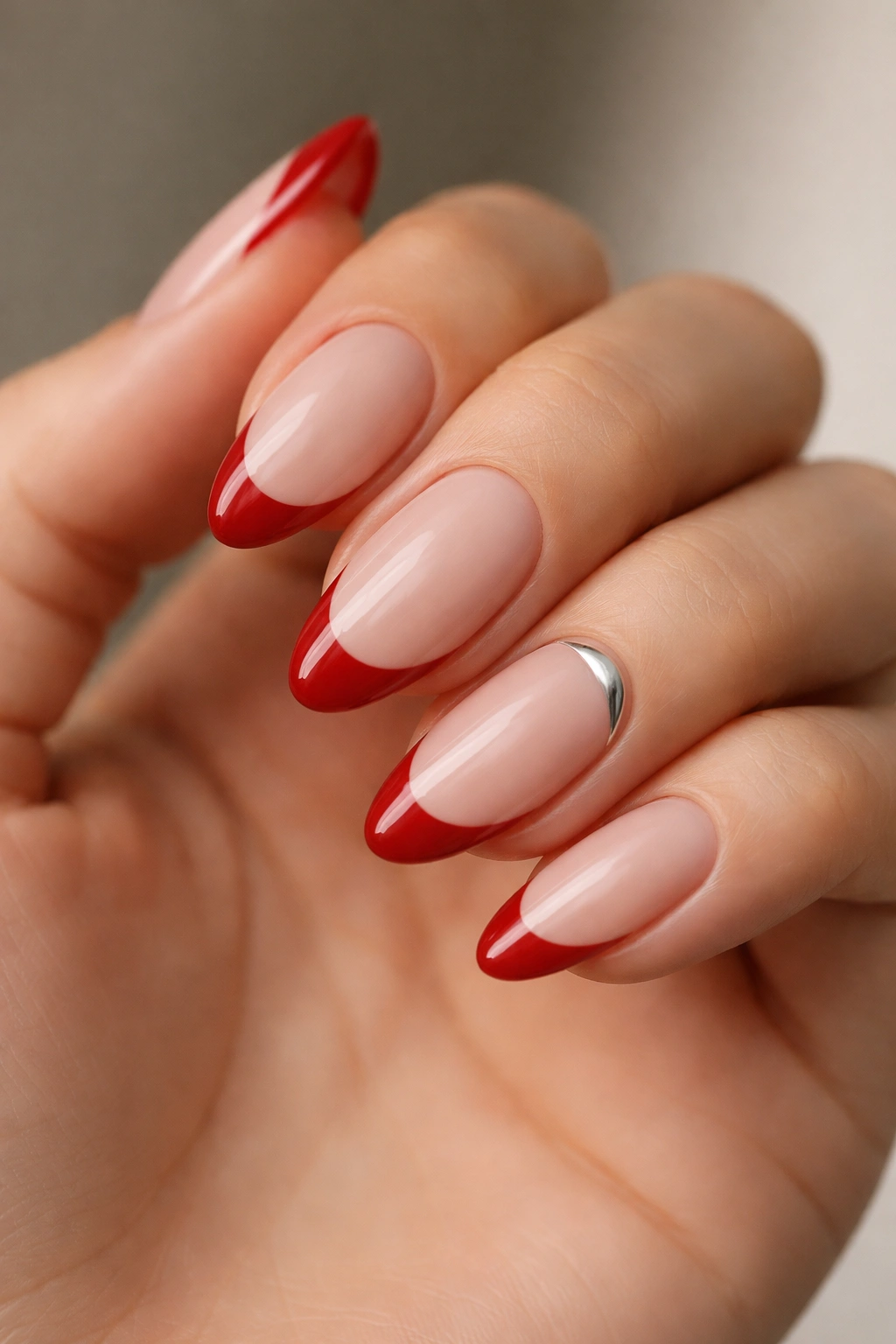 Hand with mixed-finish cherry red French manicure and one accent nail