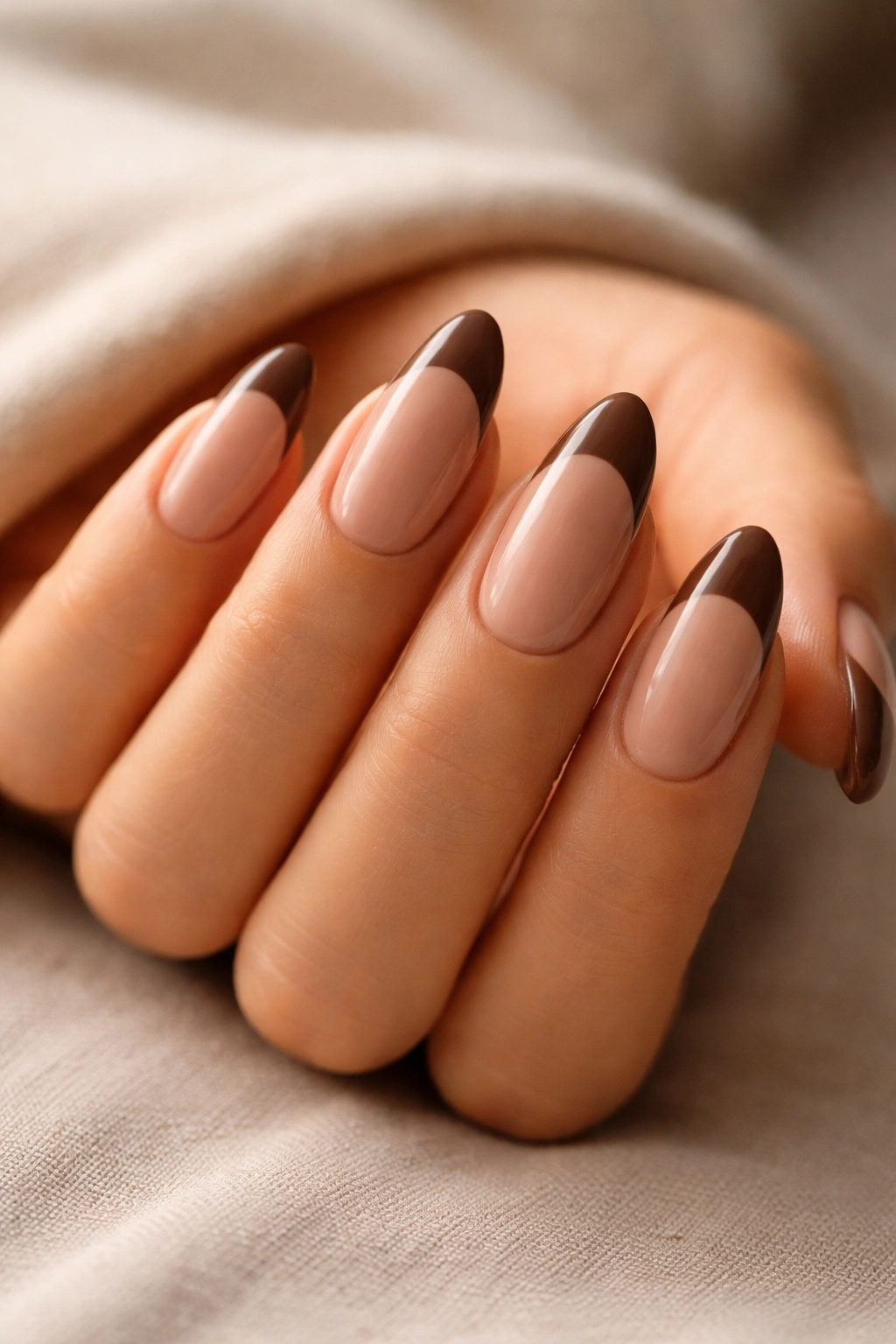 Almond nails with mocha brown tips on a warm nude base