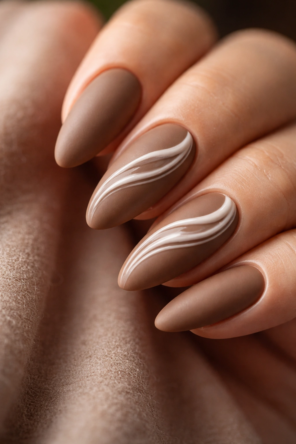 Close-up of Mocha Nails With Foam Swirls showing latte base and white swirl on almond nails
