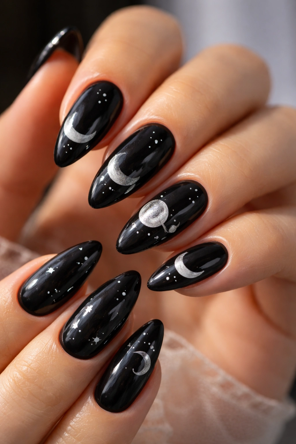 Close-up of black almond nails with moon-phase tips