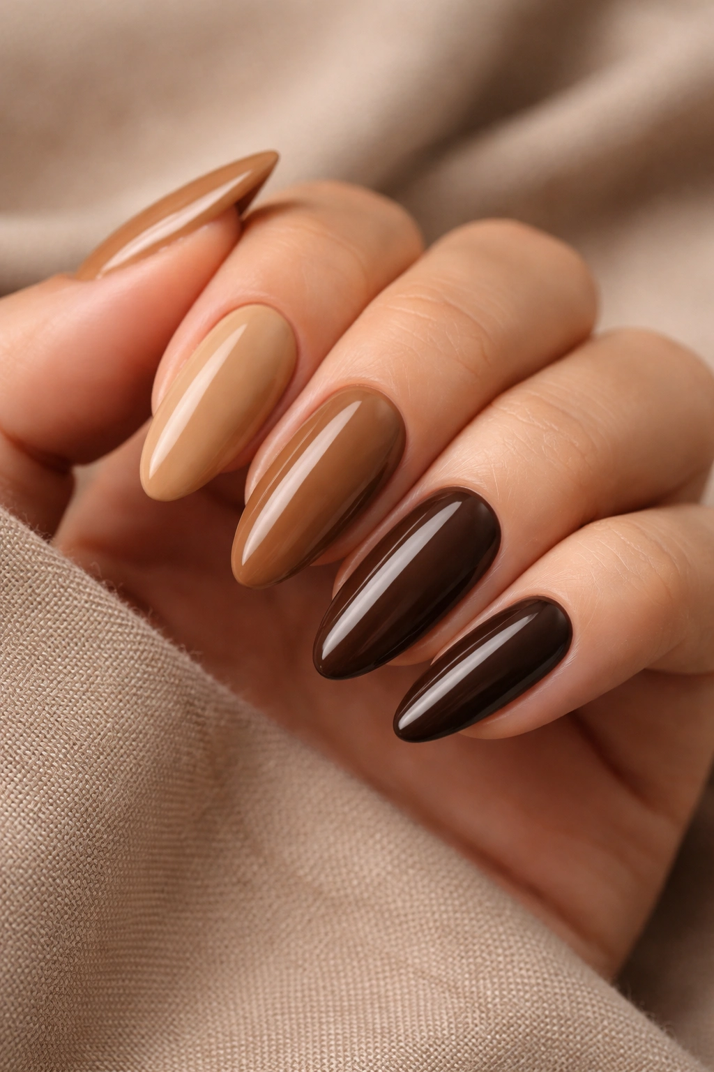 Almond nails in five brown shades arranged as a skittle