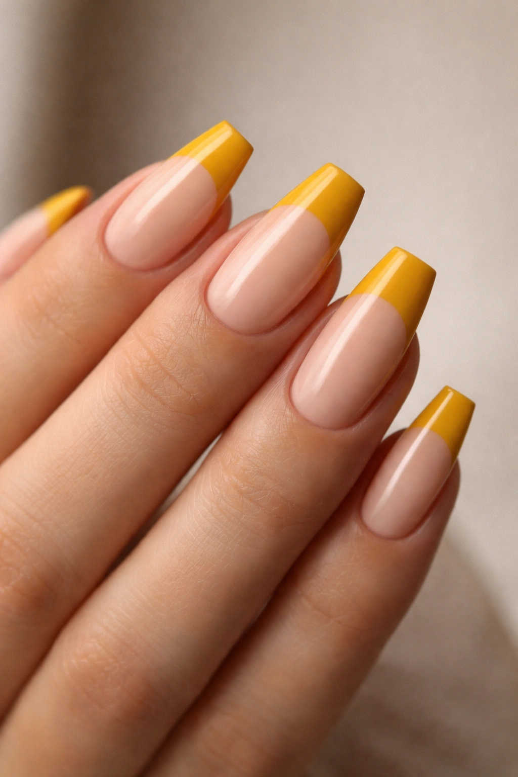 Almond nails with mustard block tips on a nude base and sharp edge