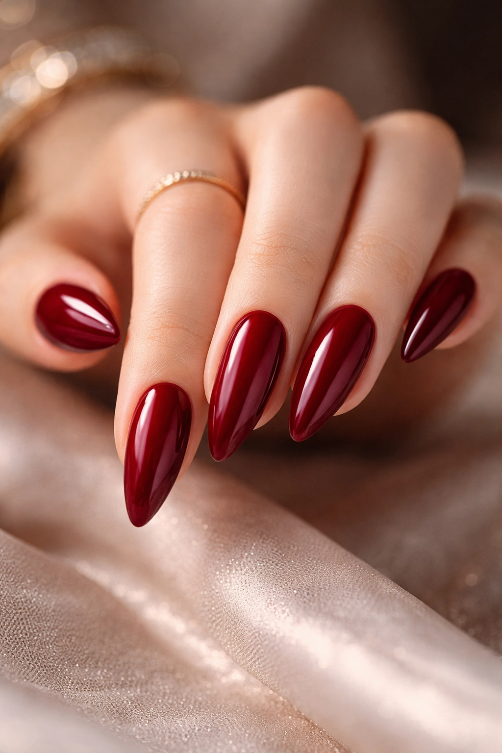 Close-up of deep cherry red almond nails with glossy finish