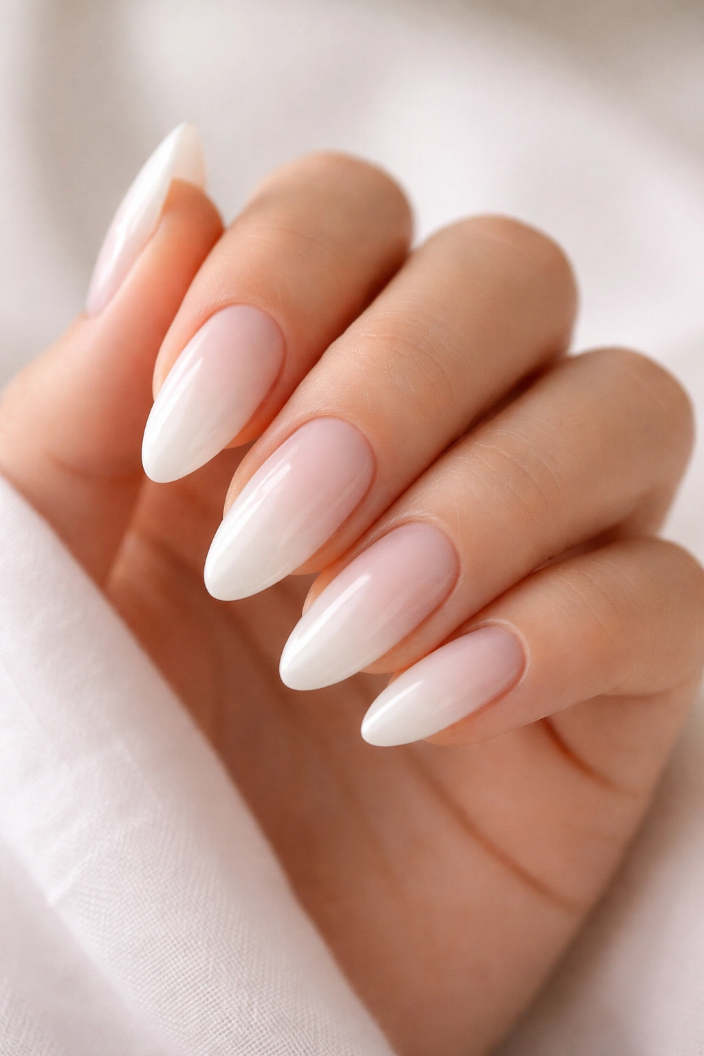 Close-up of milky white almond nails with translucent base