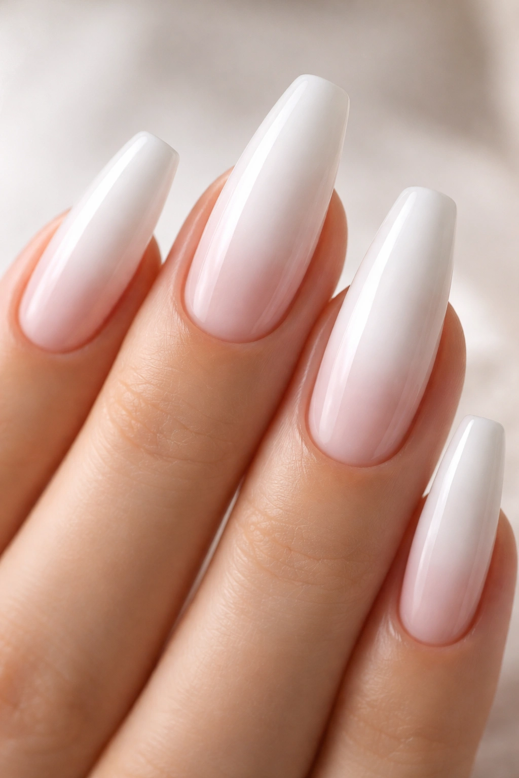Close-up of nails with a white center fade and translucent edges.