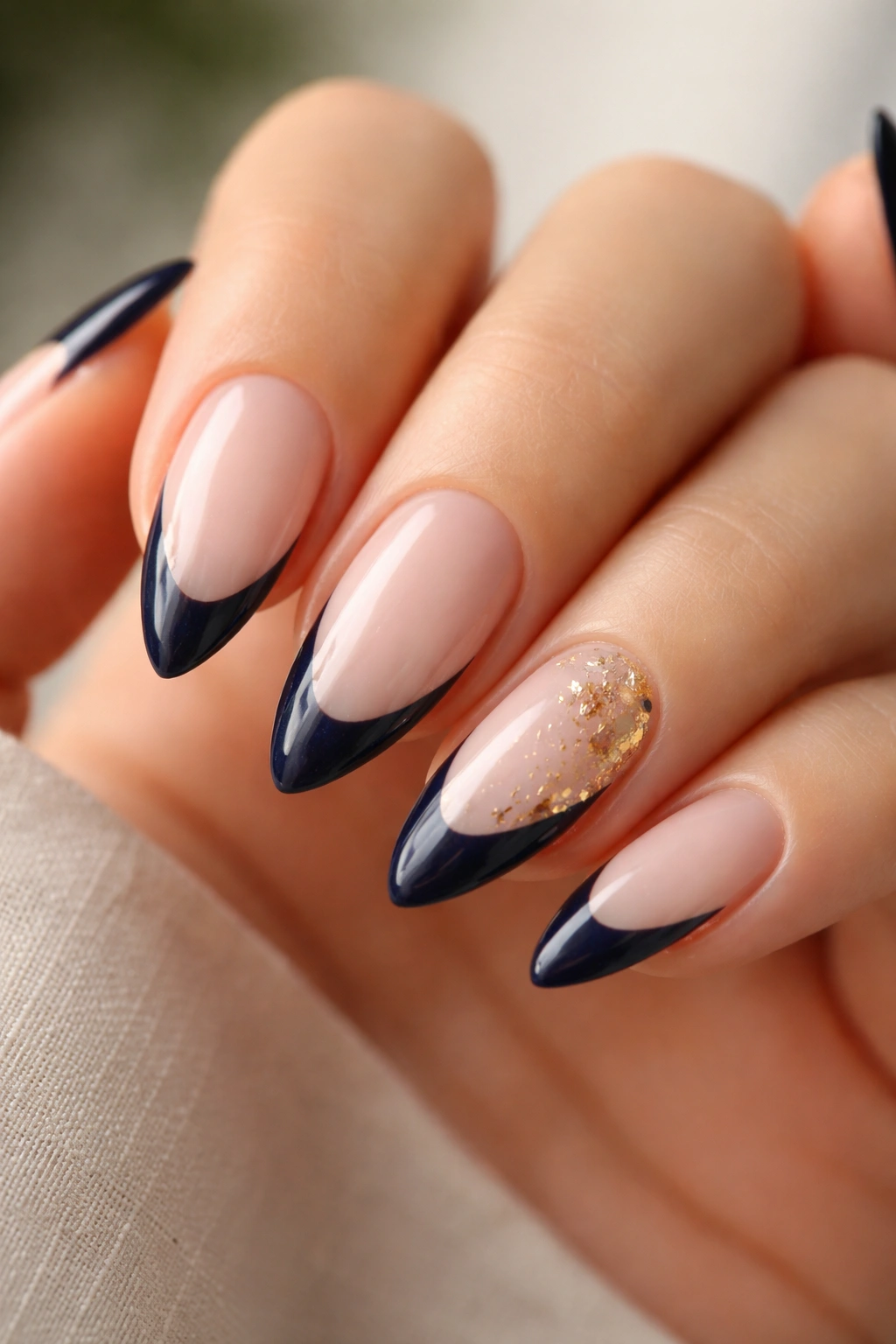 Almond nails with navy tips and gold foil accents