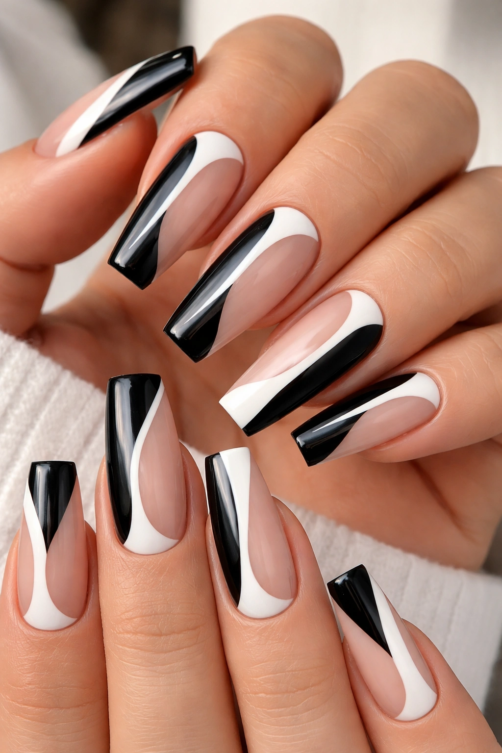 Negative-space coffin nails with black and white cutouts on a sheer base.