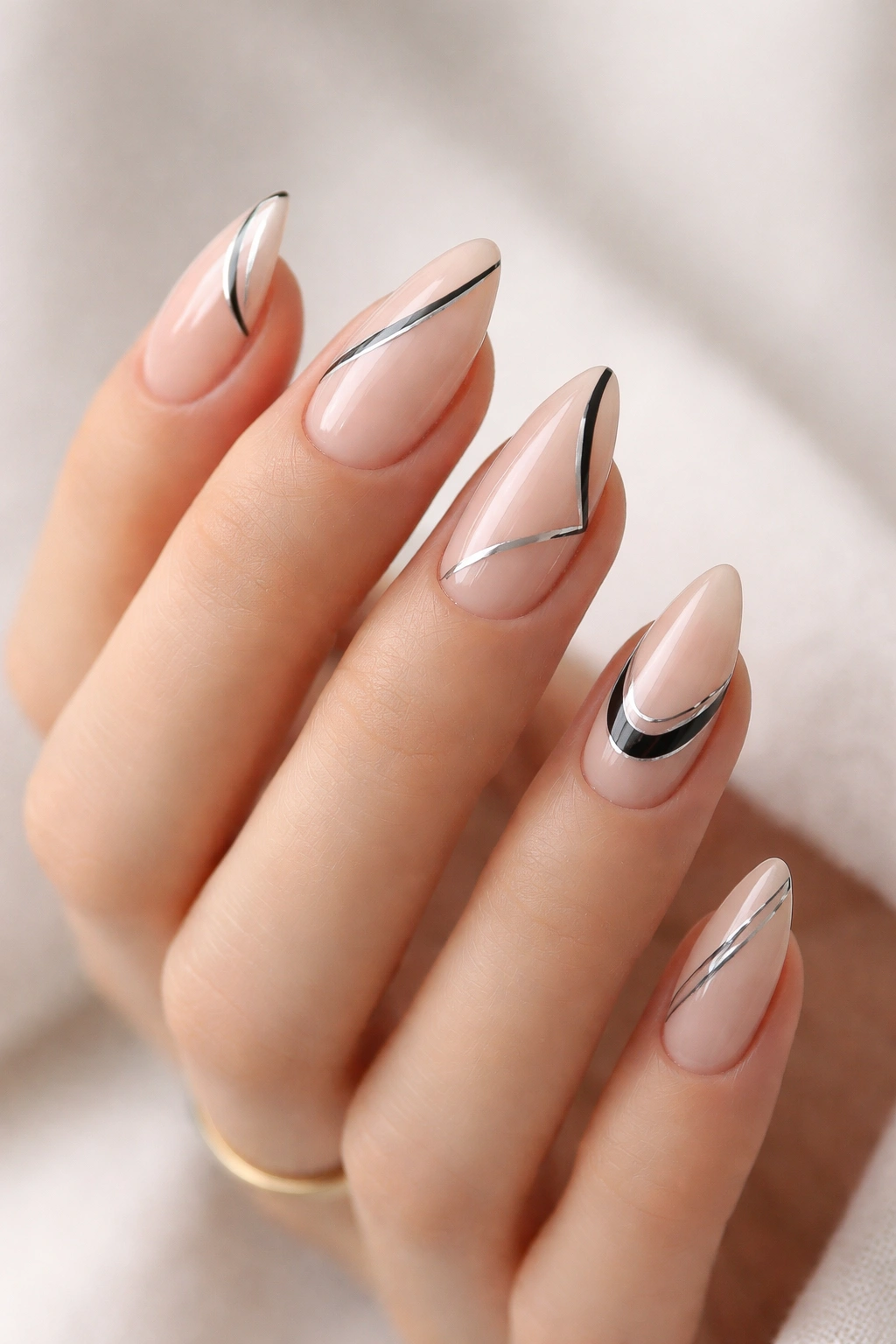 Close-up of negative-space almond nails with crisp lines and cutouts.