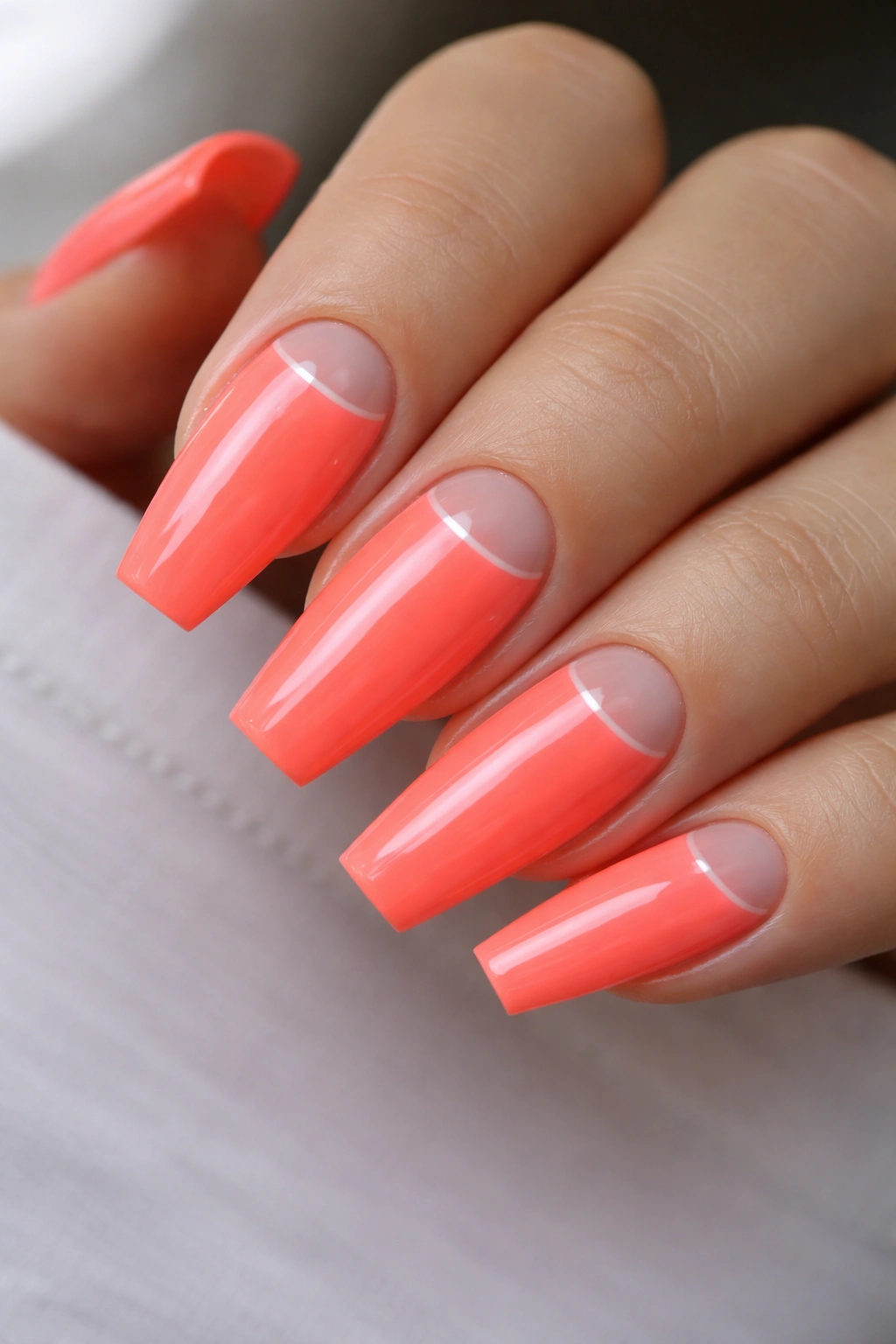 Coffin nails with neon coral and a clear crescent at the base
