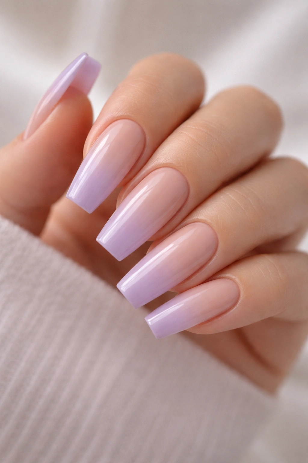 Close-up of nude-to-lilac ombre coffin nails with smooth gradient.