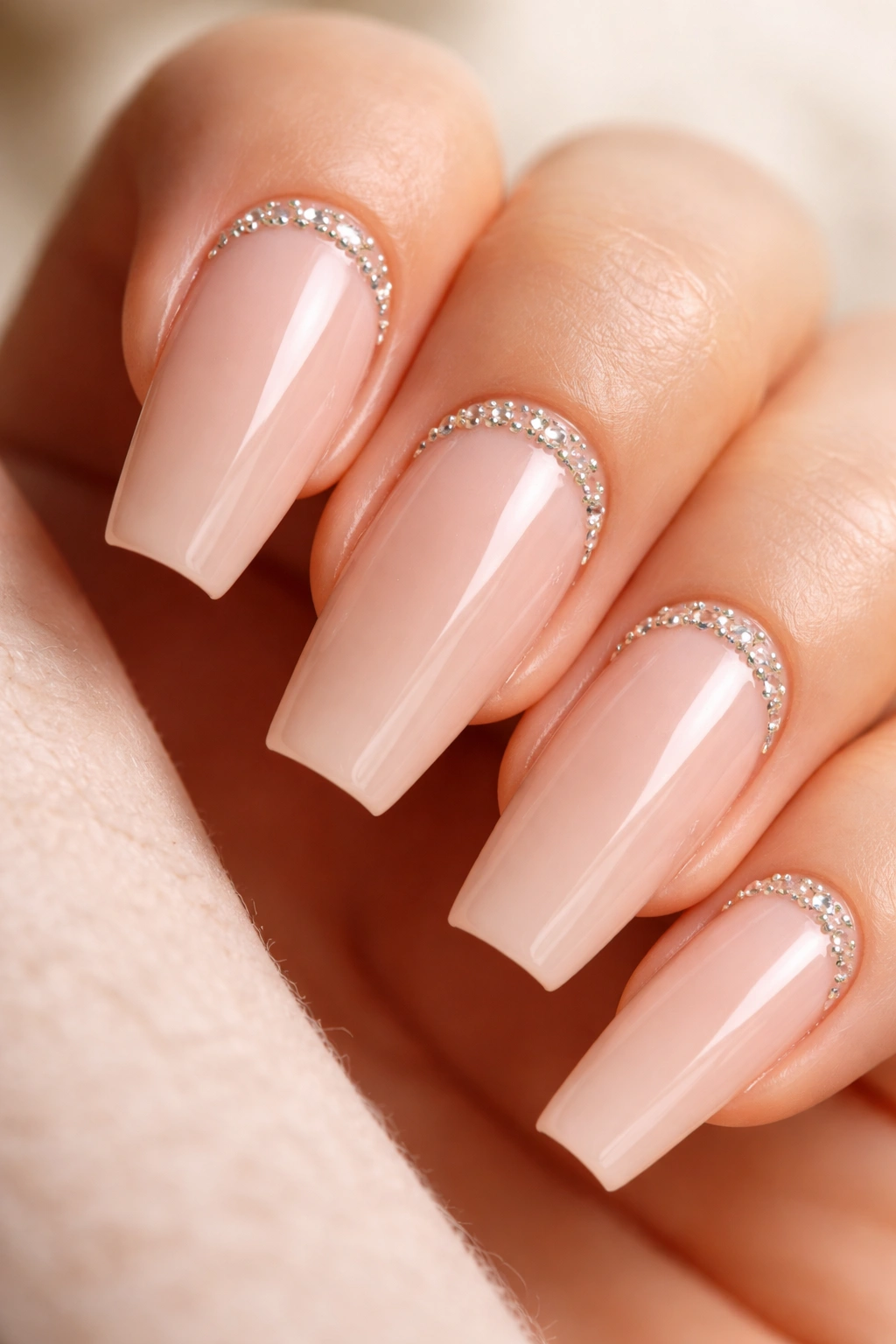 Nude coffin nails with small crystals along the cuticle on accent nails.