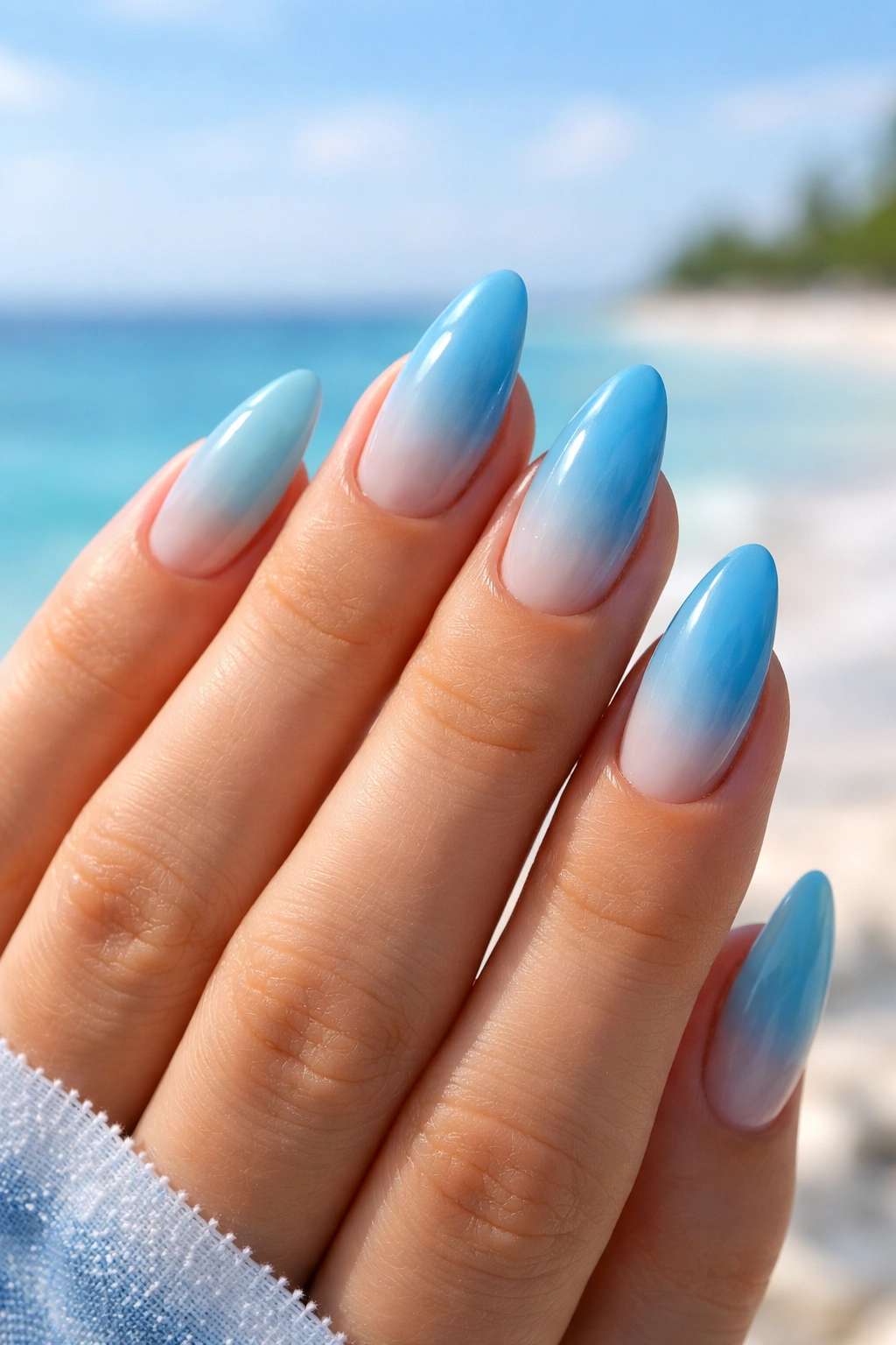 Almond nails with pale aqua to blue ombre gradient and glossy finish