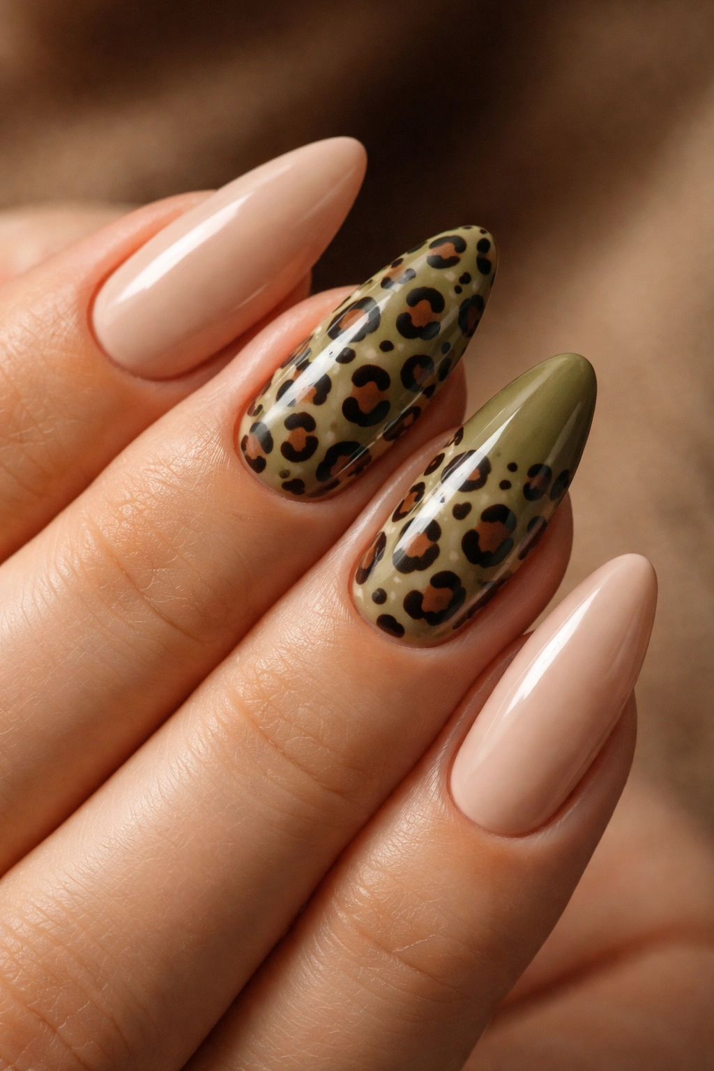 Almond nails with olive green leopard accents against muted nude base