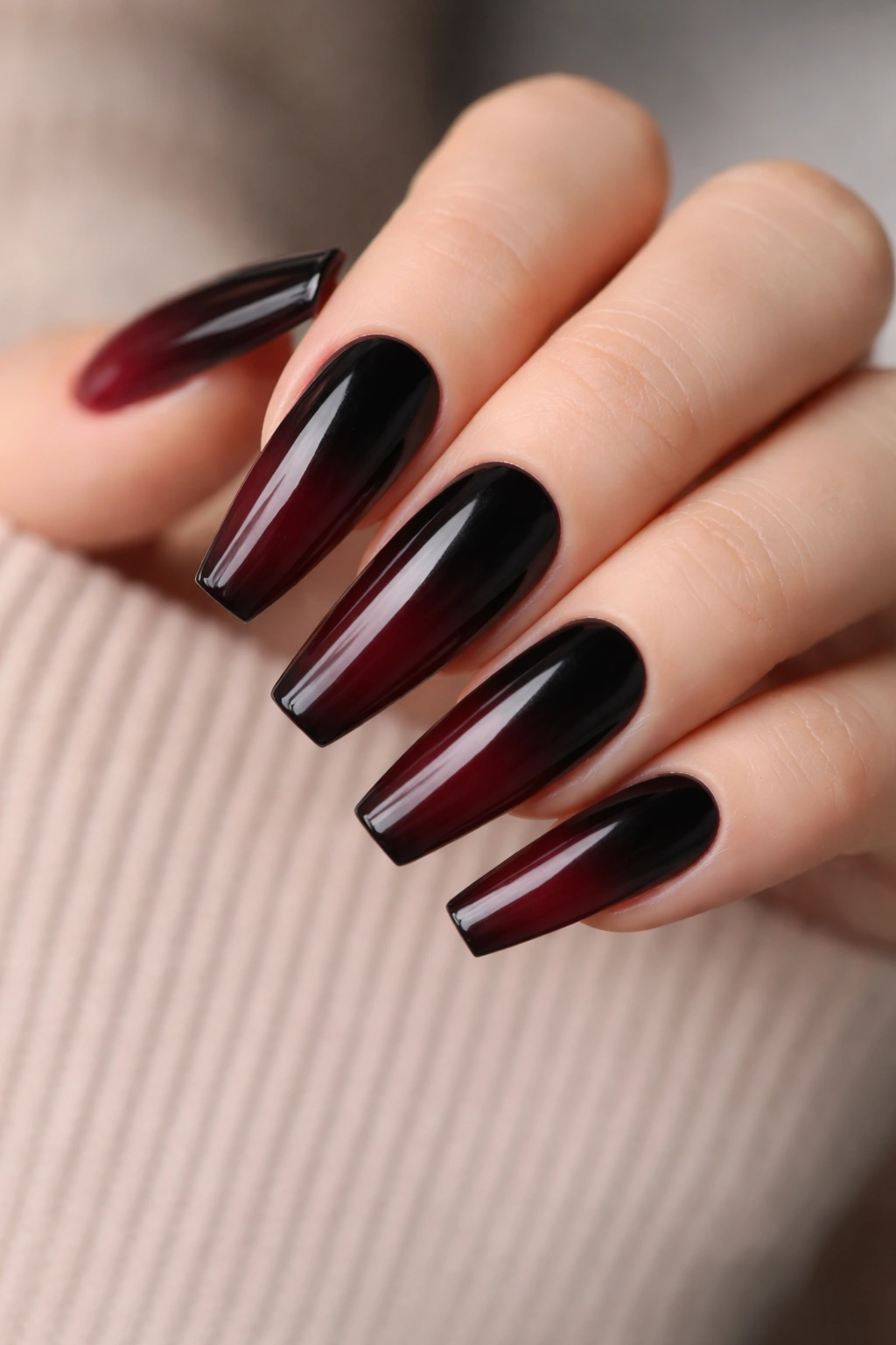Close-up of black to burgundy ombre coffin nails