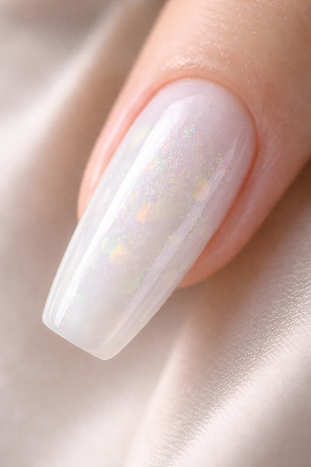 Close-up of white opal layered gel nail with subtle iridescence on a ballerina nail