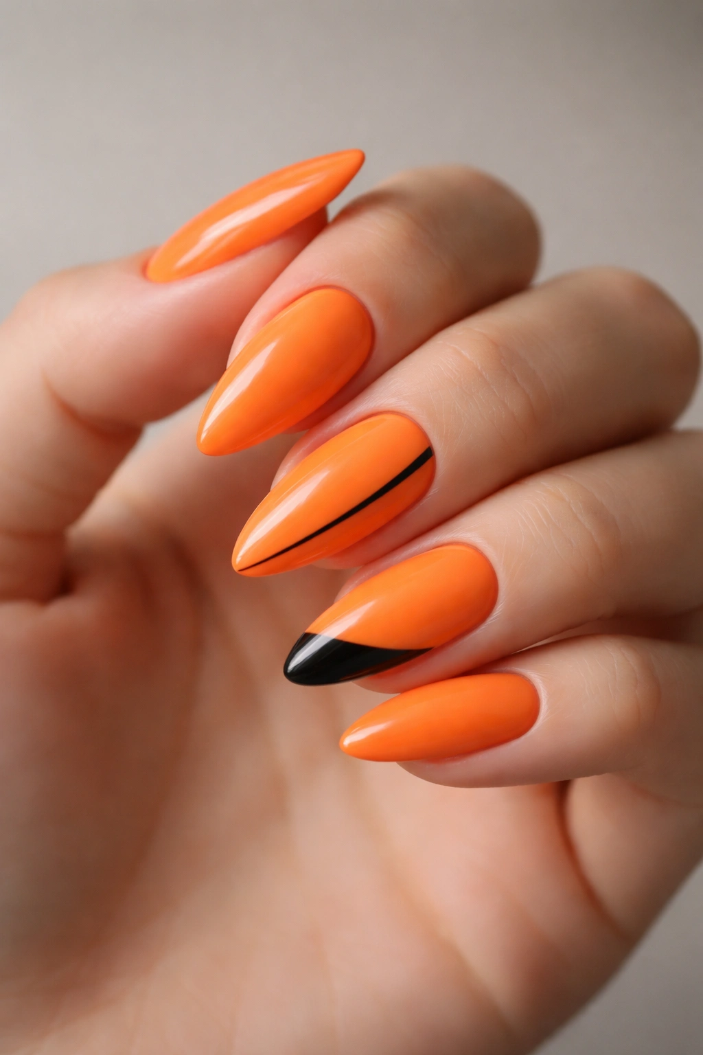 Almond nails with orange base and black accent details