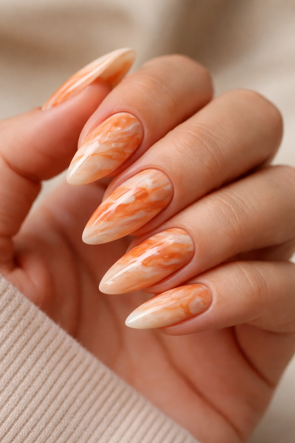Almond nails with orange marble pattern and white veins