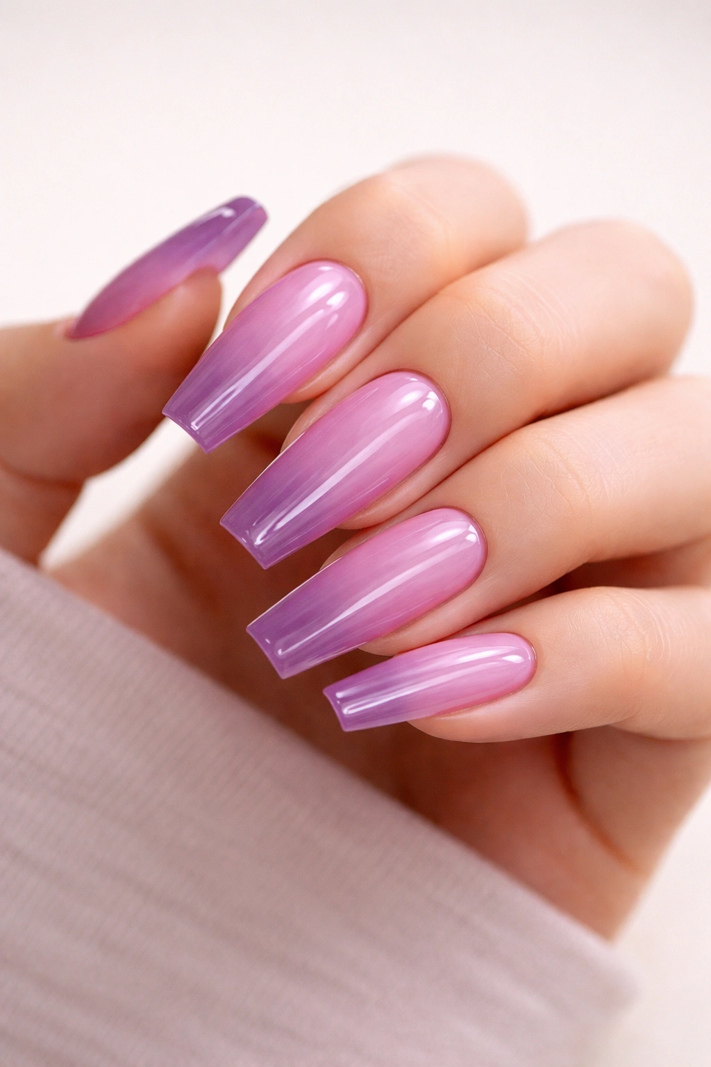 Close-up of translucent orchid jelly coffin nails with glassy depth