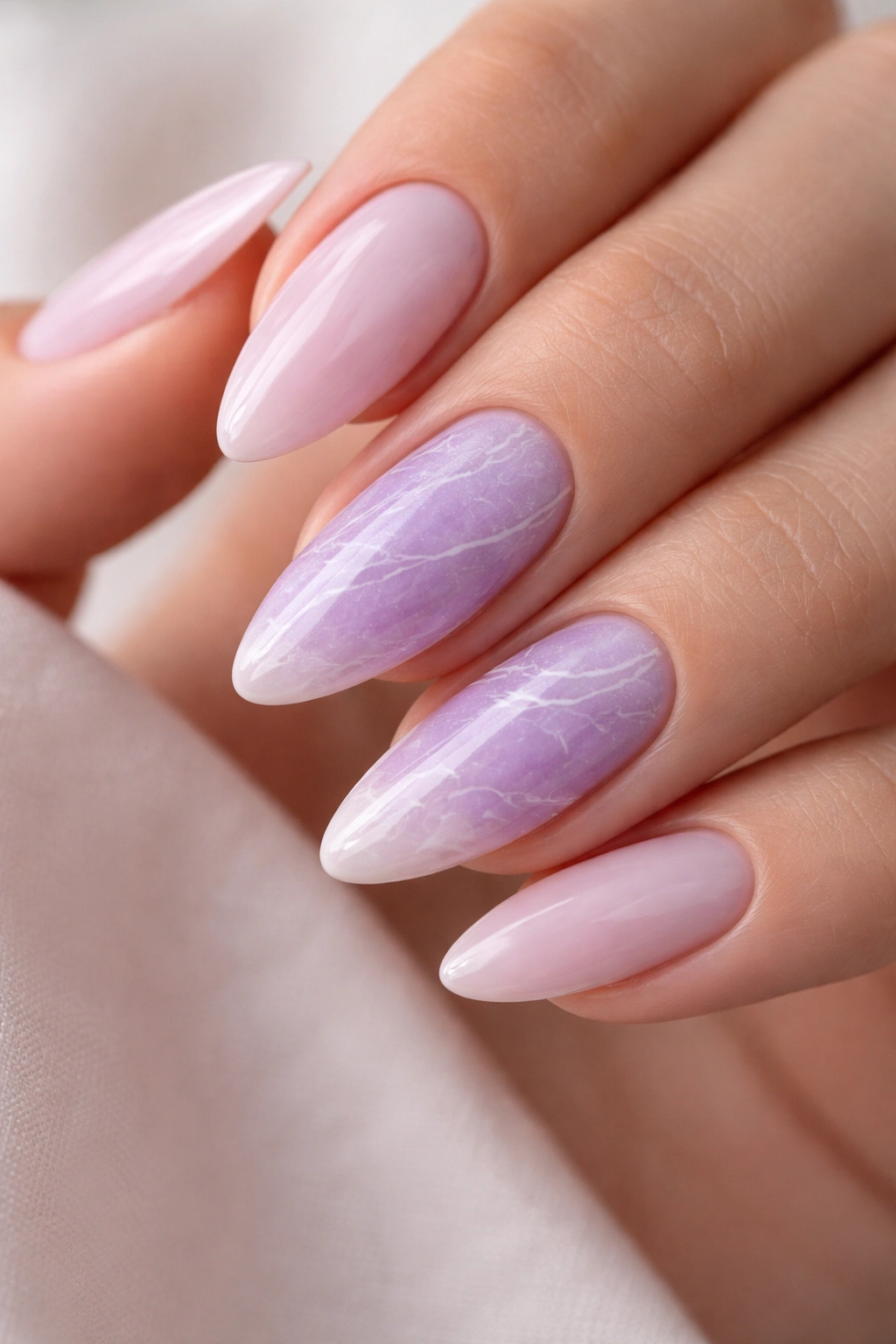 Close-up almond nail with orchid marble and white veins