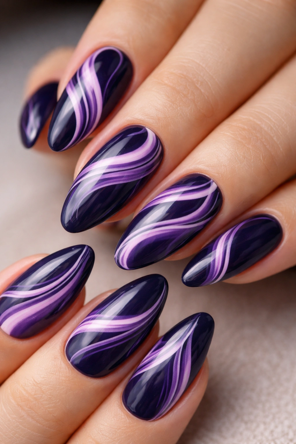 Navy almond nails with orchid swirls and subtle white accents.