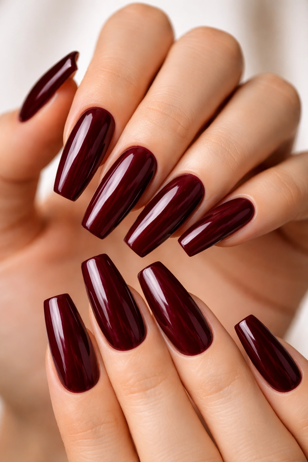 Close-up oxblood red coffin nails with plum undertone