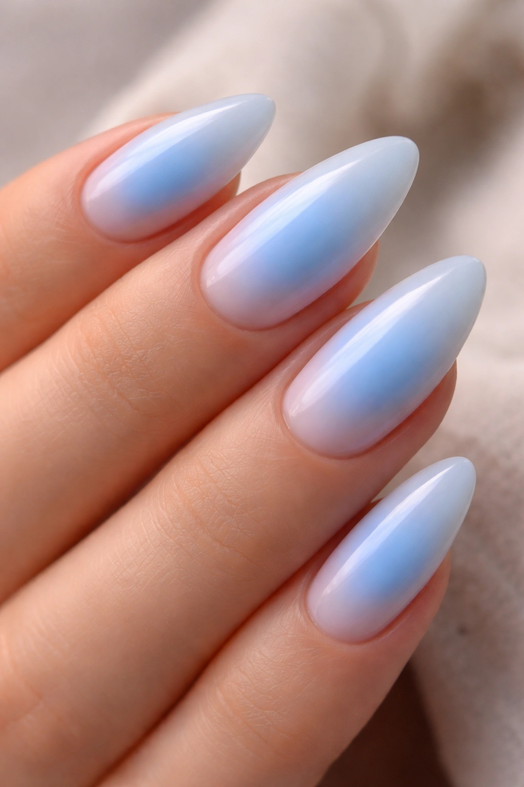 Close-up of almond nails with a soft glow aura effect