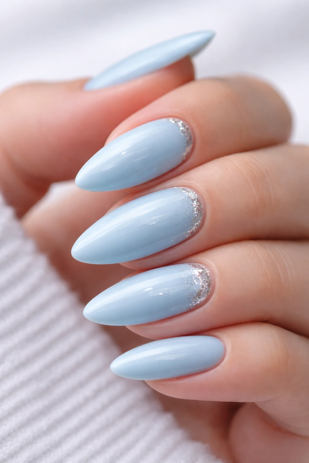 Pastel blue nails with silver glitter accents