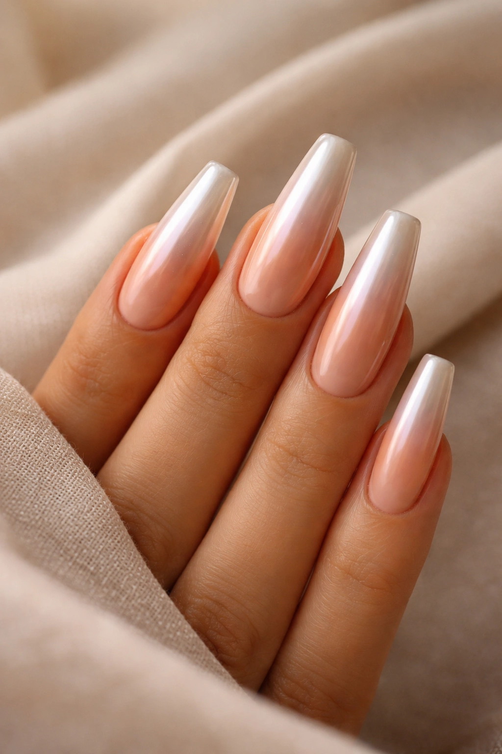 Nude peach ombre coffin nails with pearl chrome finish.
