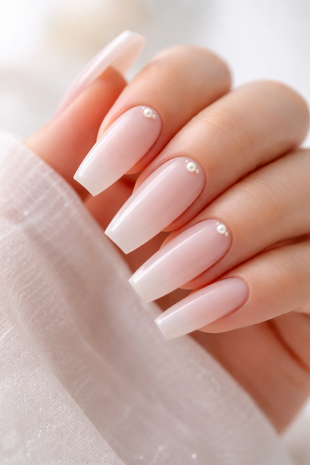 Close-up of bubble bath coffin nails with tiny pearl accents near the cuticle