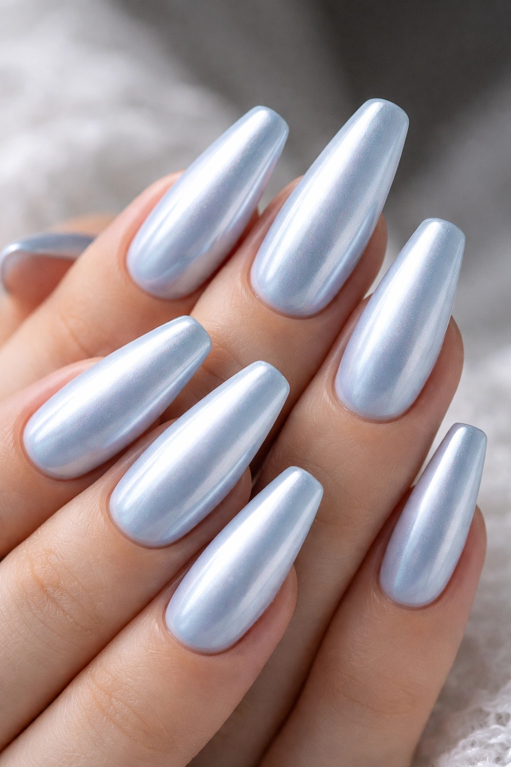 Close-up of pale blue nails with satin pearl chrome finish