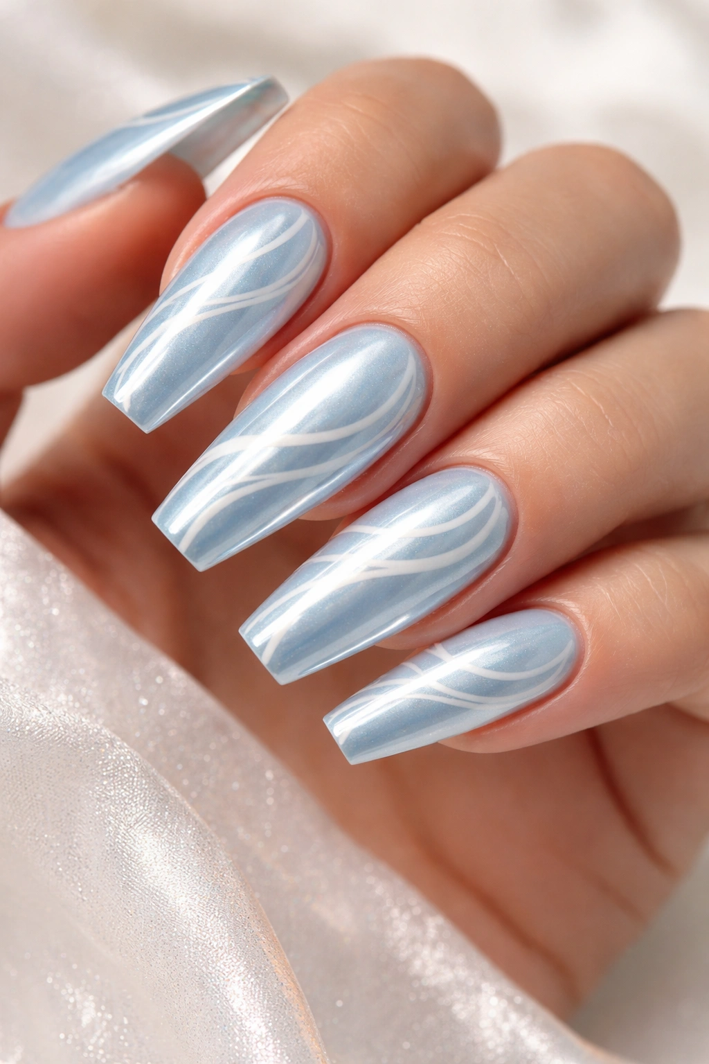 Close-up of Pearly Light Blue Chrome with White Swirl Art on coffin nails with movement