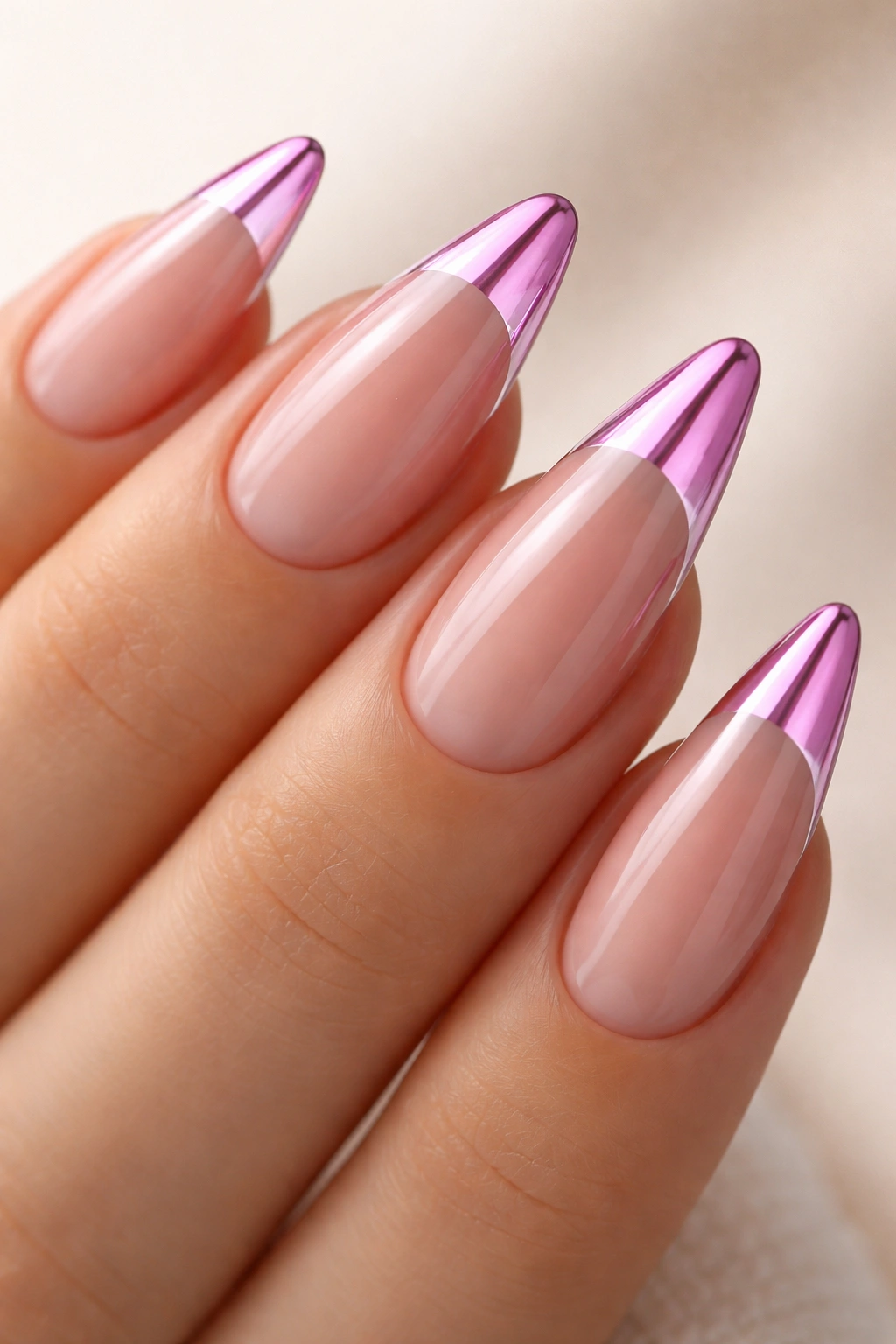 Close-up of almond nails with pink chrome tips and clear tips on a sheer nude base