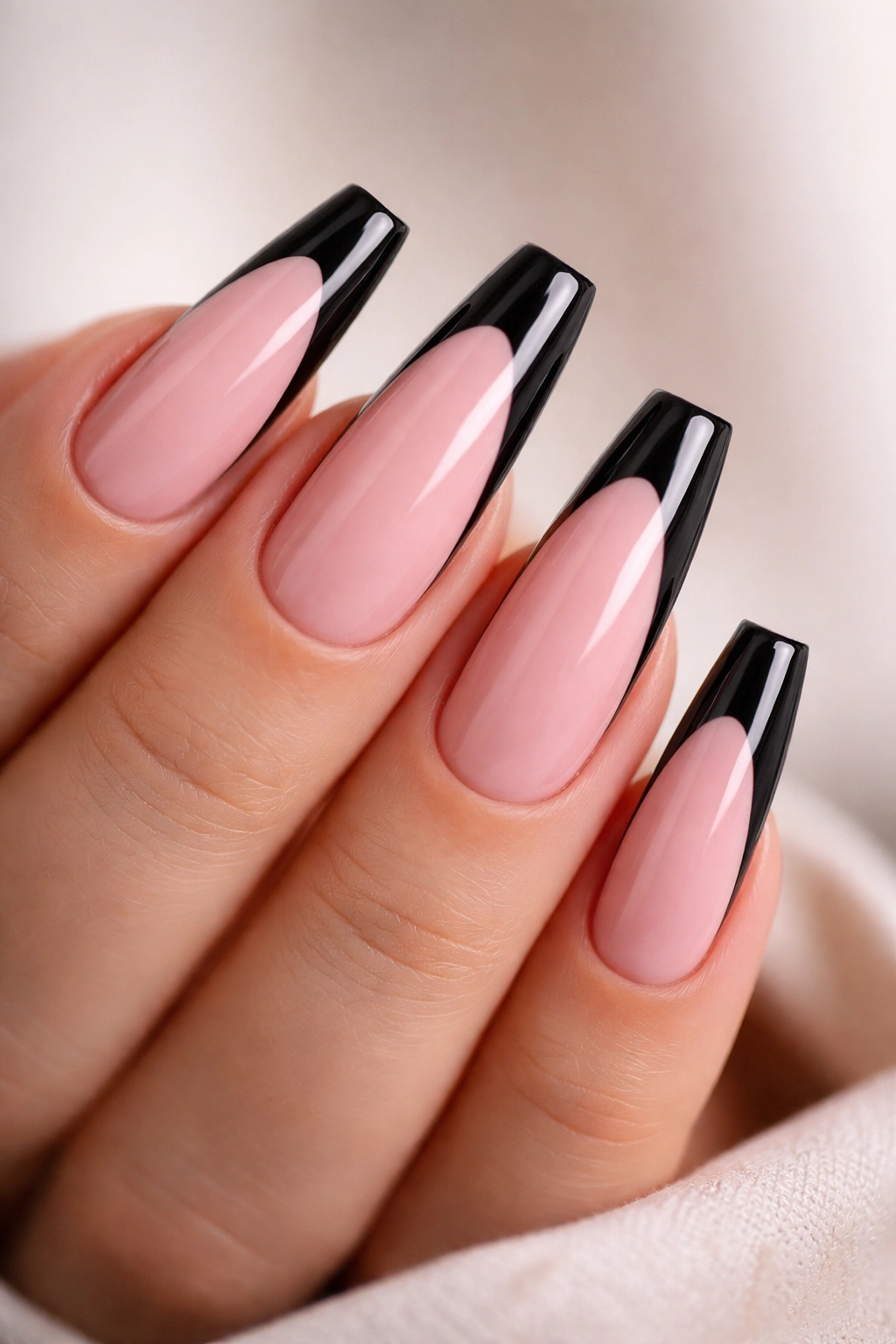 Close-up of pink and black coffin nails on a hand showcasing sharp coffin shape and contrast
